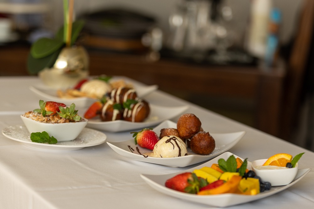Sisi Olonje dessert spread — puff puff, fruit crumble, waffles and fruit platter beautifully displayed