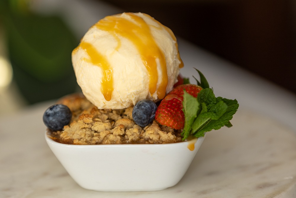 Fruit crumble served with vanilla ice cream and caramel sauce