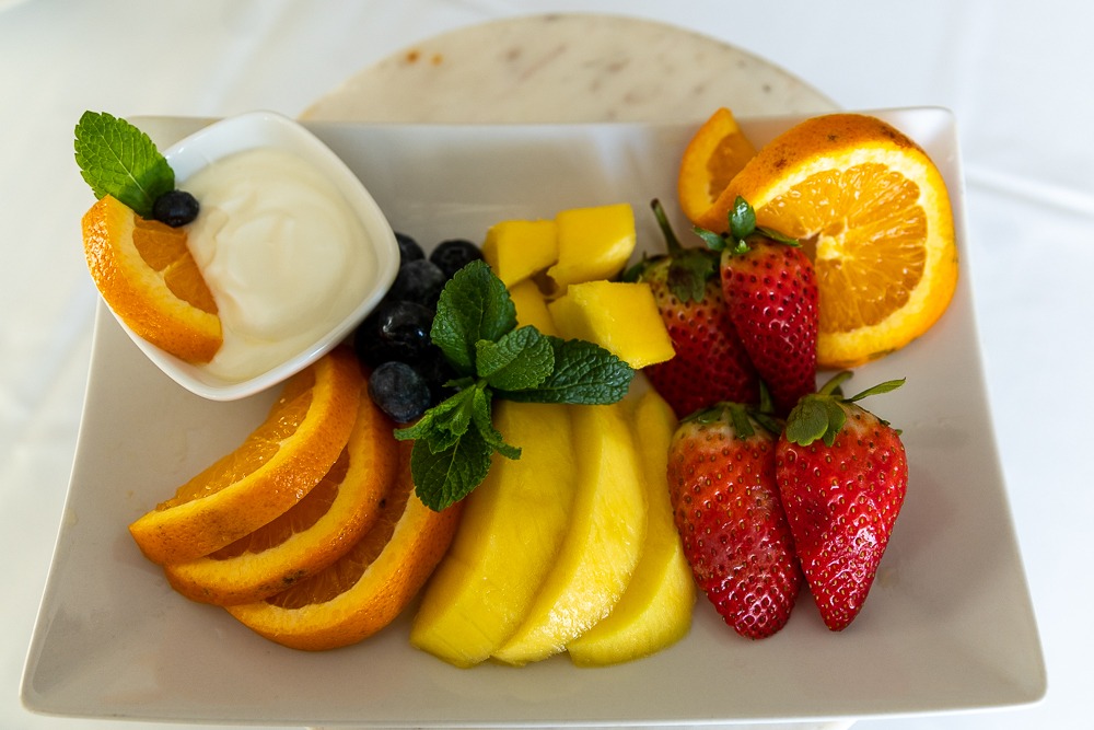 Fresh fruit platter with mango, strawberries, orange and blueberries