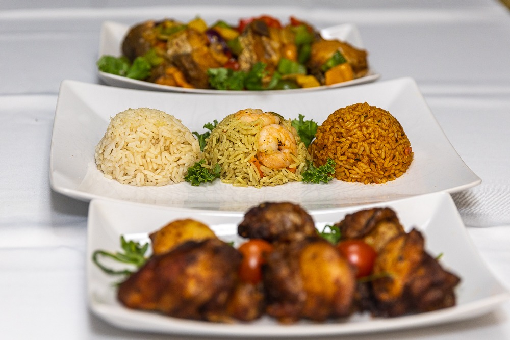 Sisi Olonje signature spread — jollof rice, grilled chicken and escovitch fish