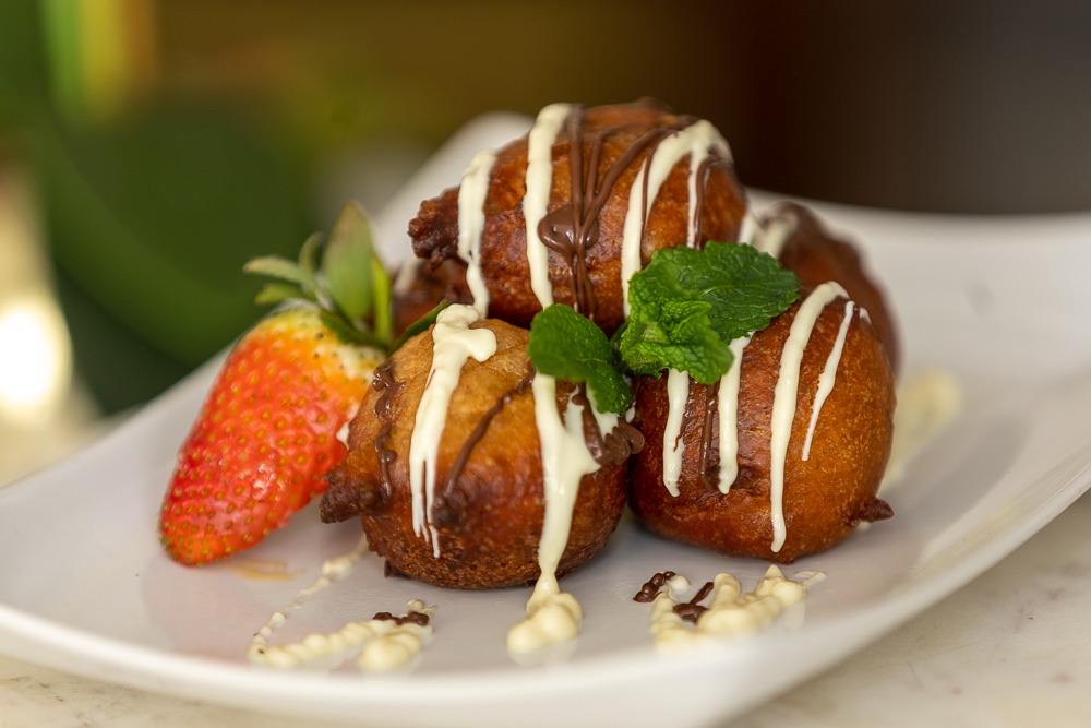 Puff puff with white and dark chocolate drizzle, mint and strawberry